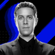 Game Awards host Geoff Keighley poses in a black suit in front of a blue and black background.